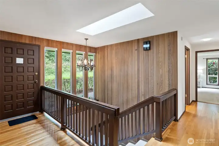 This is the entryway into the home. Notice the oak hardwood flooring, skylight, and lots of windows.