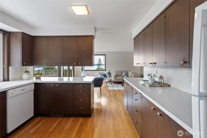 Another view of the kitchen, which has plenty of cupboard space and countertops. Stove/range, refrigerator, dishwasher, microwave, and washer and dryer remain with the home.
