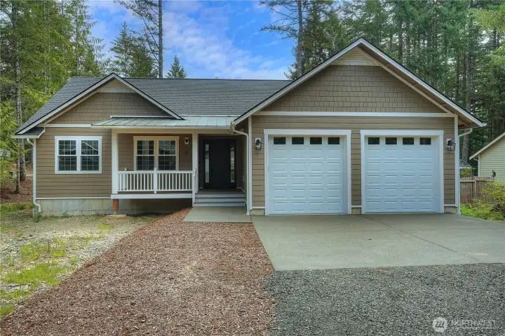 New rambler on corner lot.  Nice metal roof detail over the front porch & shingles on gable fronts.  9' high garage doors.