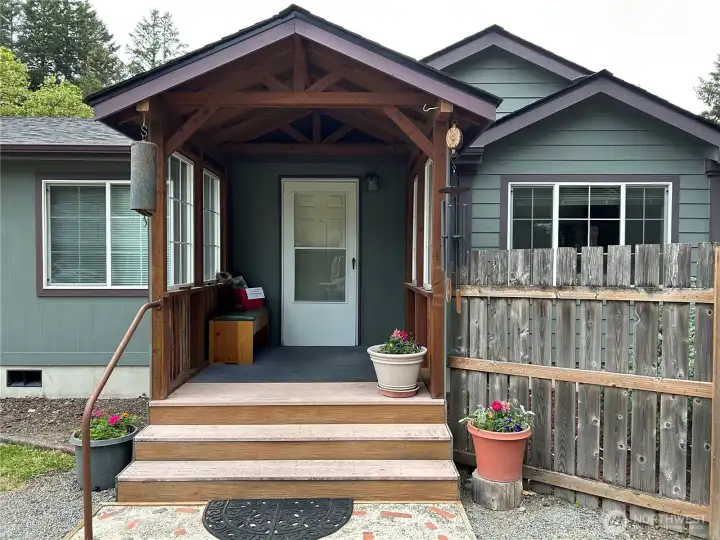 Enclosed and covered front porch adds Architectural Appeal, Charm, and Convenience for removing shoes while protected from the elements.