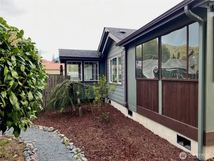 Front view of home with inviting and enclosed front porch. Solid, poured concrete foundation.