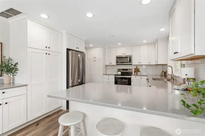 2 large pantry cabinets in this fully remodeled kitchen w/pull out drawers, stainless steel appliances, quartz counters and LVP flooring