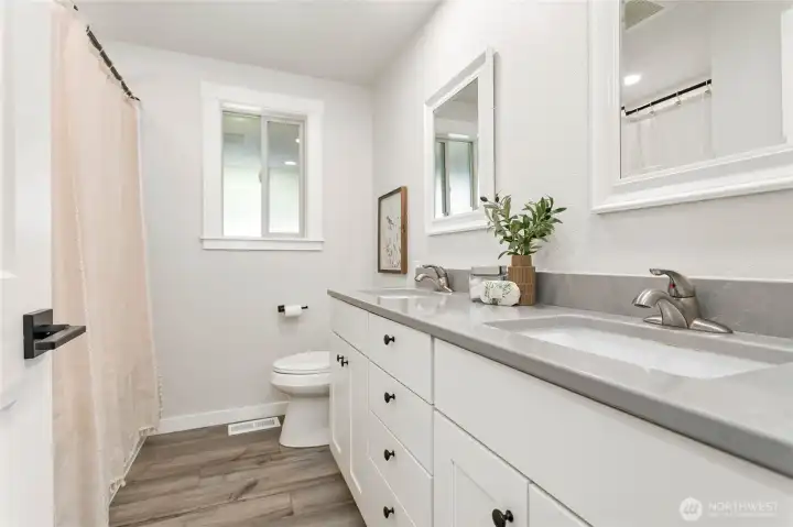 Full size bathroom down hall near 2nd & 3rd bedrooms features dual vanity & quartz counters