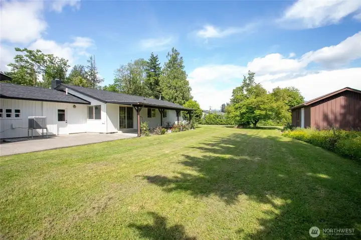 Just look at the size of that backyard! Huge patio extends beyond covered area. Beautiful wildflower garden and another large outbuilding