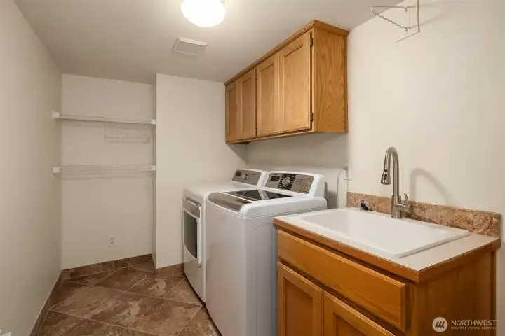 A larger main level laundry room with sink & full size washer and dryer (Included)