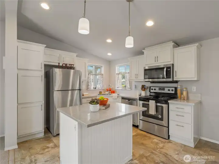 The white kitchen with gray countertops has a classic fresh look.