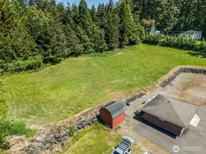Drone view of field with 2 car garage and shed