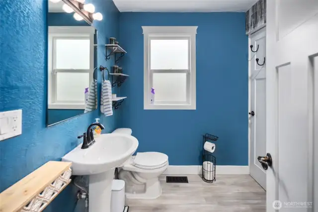 On your left, we have a bright and cheery bathroom with a frosted glass window for added privacy.