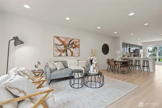 Bright and open living room with oversized windows, luxury vinyl plank flooring, and mini-split heating and A/C.