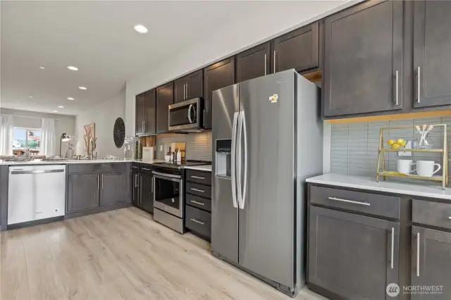 Ample cabinetry, electric range, and peninsula seating – a chef’s kitchen with style and function.