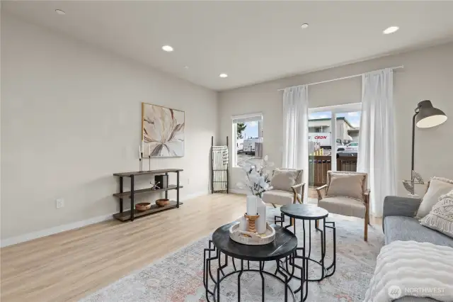 Bright and open living room with oversized windows, luxury vinyl plank flooring, and mini-split heating and A/C.