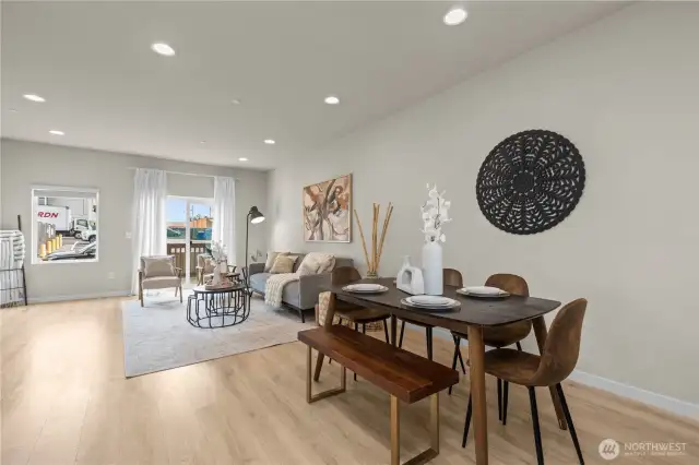 Bright and open living room with oversized windows, luxury vinyl plank flooring, and mini-split heating and A/C.