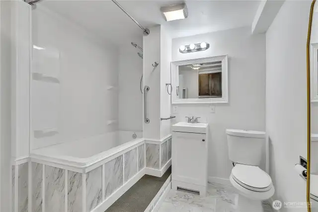 Lower level bathroom with a second laundry area.