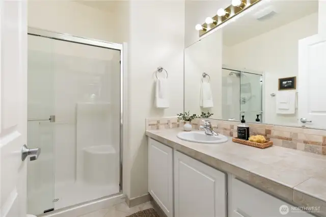 Secondary bathroom with sliding glass walk-in shower.