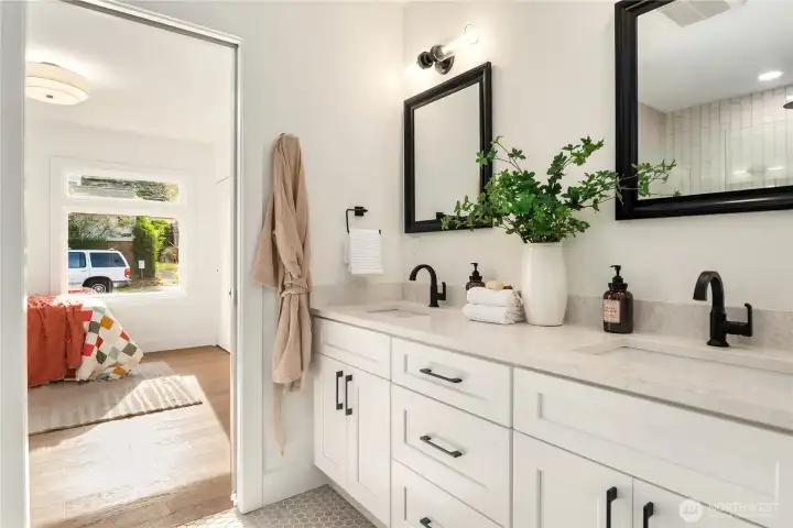 A double vanity with extra storage is capped by honed quartz counters.