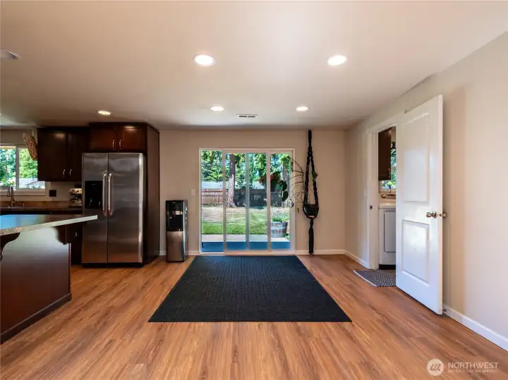 View from the living room into the dining area with kitchen to the left & utility room & 2nd bath on the right.