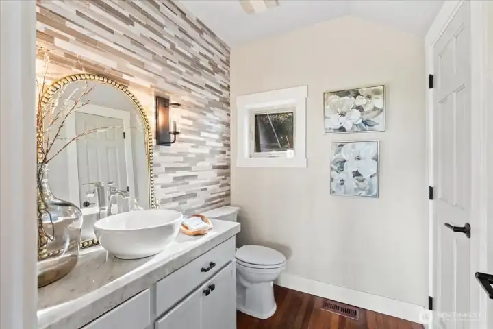 All bathrooms thoughtfully remodeled.  This half bath has marble counters and a tiled floor to ceiling back splash.