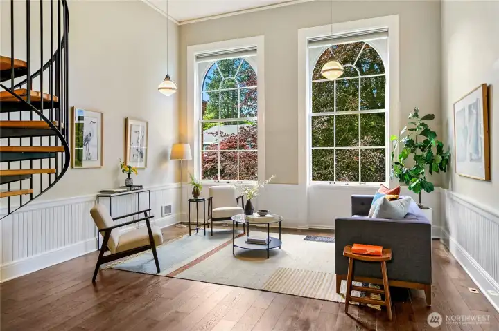 Expansive Palladian windows draw natural light deep into the residence while framing views of mature landscaping and the surrounding campus grounds.