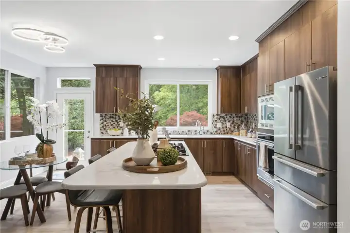 A bright, inviting kitchen featuring a gorgeous, hardworking island with gas range, plenty of countertop workspace, and newer stainless steel appliances. A bright, inviting kitchen featuring a gorgeous, hardworking island with gas range, plenty of countertop workspace, and newer stainless steel appliances.