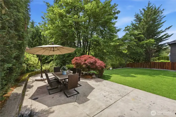 Step outside the kitchen and this lovely patio welcomes you to the garden. A built-in firepit with seating sits just beyond the table, out of sight. Step outside the kitchen and this lovely patio welcomes you to the garden. A built-in firepit with seating sits just beyond the table, out of sight.