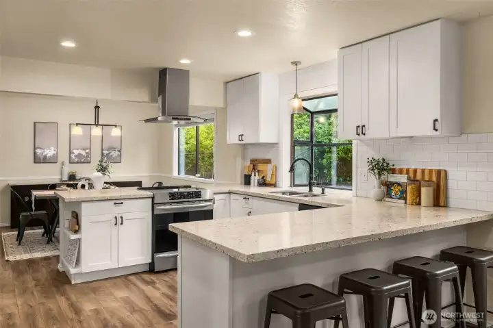 Sprawling quartz countertops, generous cabinetry, and views to the backyard.