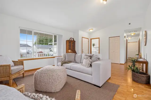 Looking across the living room toward the front entry with the laundry room beyond.