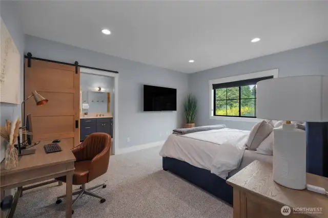 Primary Suite with barn door into the bath area. Custom blinds and cozy carpet!