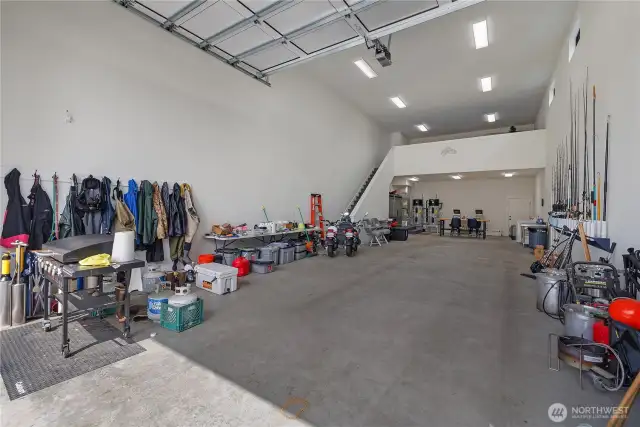 Huge attached finished shop 24x60 shop, with 20' ceilings and huge custom 14' tall by 20' wide aluminum door. Mezzanine is 424 SF. You can easily fit your boat or RV in here. Has a Twin Hybrid Hot water tanks for hot water that will not run out. Outside faucets have hot water and high pressure from a 1' main water line.