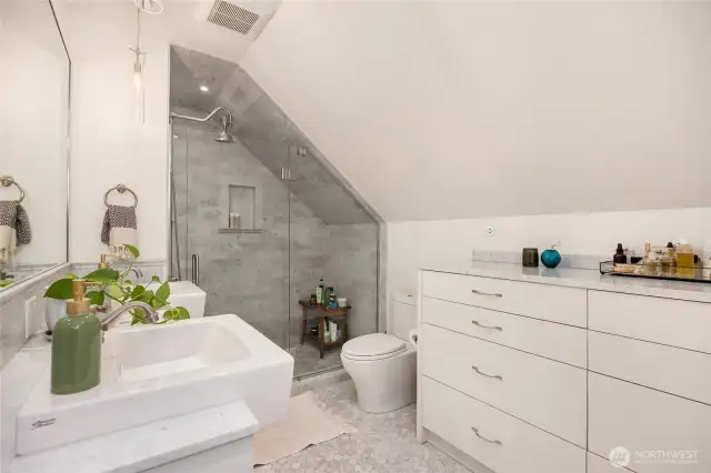 Built-in dresser with marble top to the right provides extra storage.