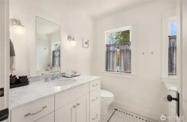 Second bathroom upstairs features period lighting and in-floor heating.