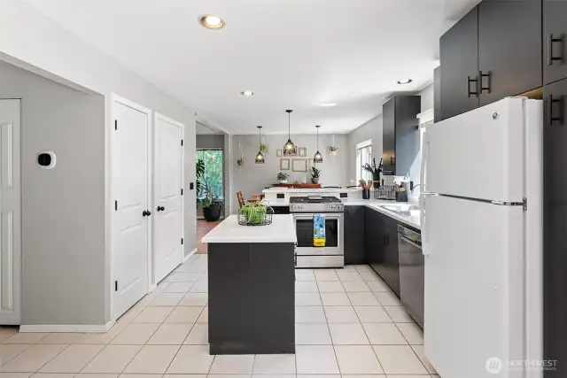 Island kitchen with pantry, breakfast bar, tile floors.