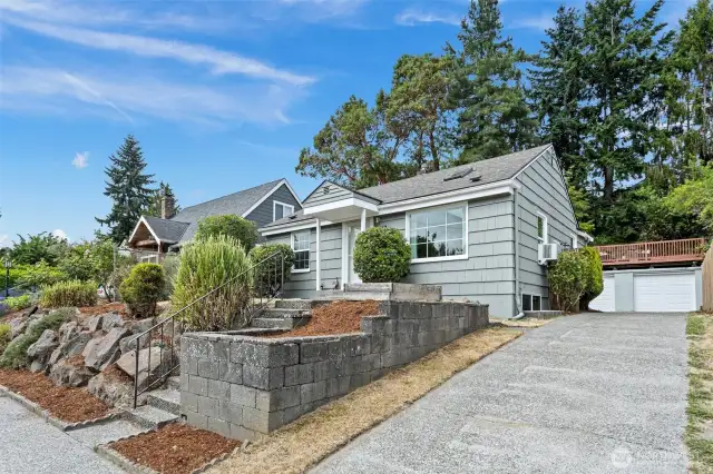 7147 welcomes you with a long driveway to a double garage in the back, topped with a view rooftop deck. This large property sits high off the street and is the perfect retreat in a great area of West Seattle.