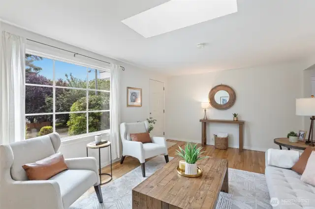 Enter into the light filled living room centered under the skylight and featuring a large picture window with colonial style grids.