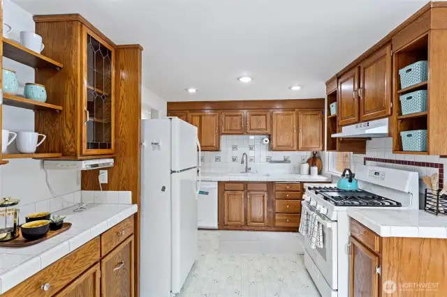 The kitchen features lots of cabinet space, a double sink and a new vented hood.