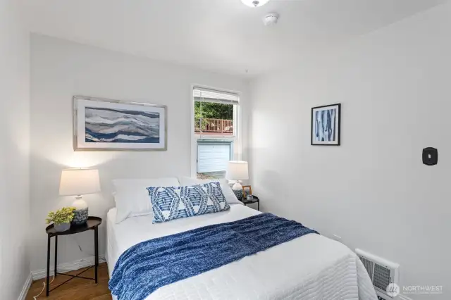 Main floor second bedroom with hardwood oak flooring and windows facing west and south, fresh paint.