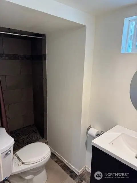The lower level bathroom features a walk-in tiled shower and free-standing vanity.