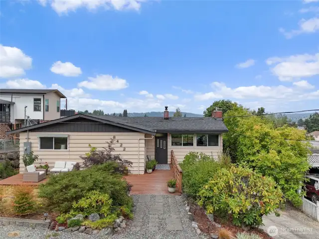 Welcome to this incredible Mid-Century Stunner!   The front of the home features a lovely large deck to welcome you.