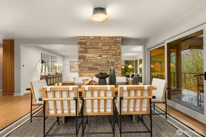 Dining area opens up to epay decking with custom steel railing, which overlooks the botanical surroundings.