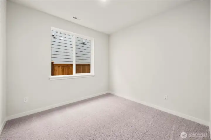 Main level bedroom. Photos of a previously completed home. Actual colors and finishes may vary. See site agent for details.