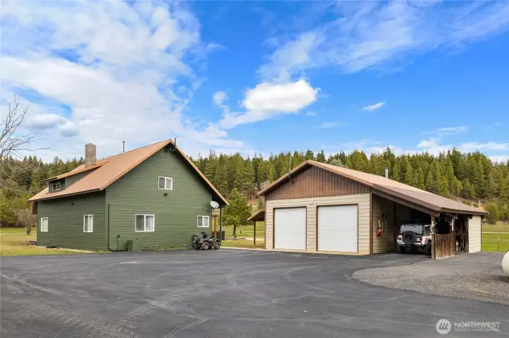 Rear of home with huge 2 car garage and covered carport. Plenty of room for parking as well.