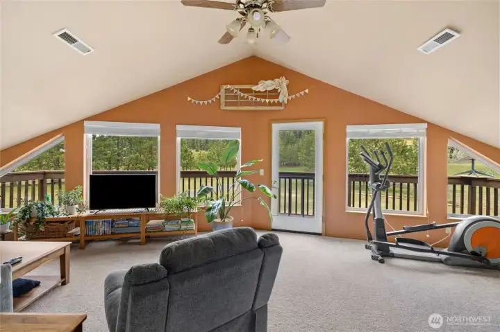 This is the second bonus room located on the upper level of the home. It features sizable windows and access to a private deck, making it a bright and versatile space.