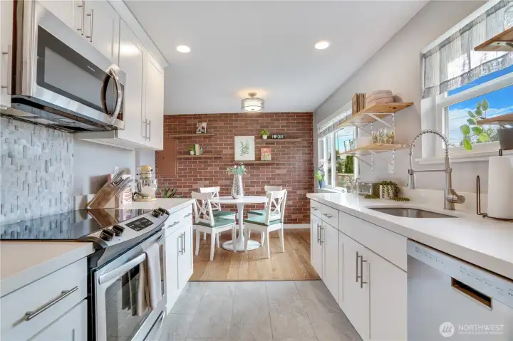 The updated kitchen features tile flooring, quartz countertops, and stainless steel appliances