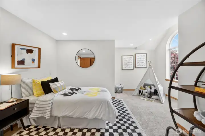 Upper level bedroom with partially vaulted ceilings and additional play area.