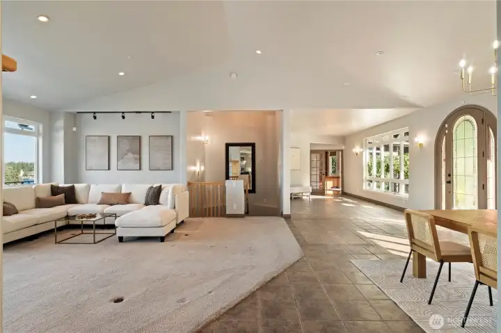 Skylit stairs lead to the downstairs rec room, 2nd primary suite and 3rd bedroom. French doors on the right lead to the sun drenched office.