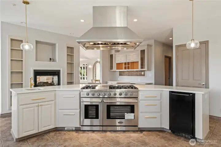 Prep sink and huge commercial gas range and see through fireplace are just a few bonuses to this amazing kitchen.