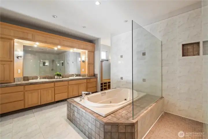 Primary suite bathroom offers large 2 sink vanity, jetted tub and expansive walk in shower with dual heads.