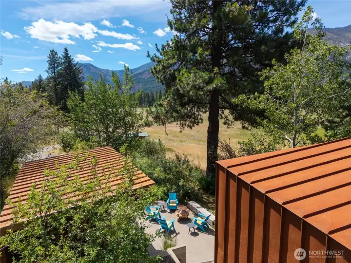 The two structures create an intimate gathering space in summer and around the firepit in cooler weather. The two structures create an intimate gathering space in summer and around the firepit in cooler weather.