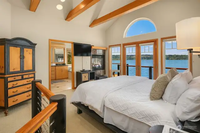 Upstairs, the sumptuous primary suite beckons to be enjoyed.  Soaring ceilings, its own private deck, double sided fireplace.  Ahhh,be lulled to sleep by the waves lapping at the shore's edge.