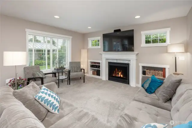 Sunny family room with built in storage and gas fireplace.