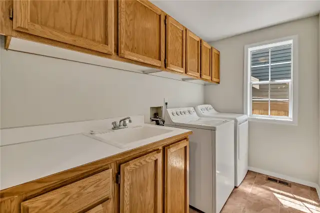 Large laundry room with sink & counterspace.  Note storage too!  Steps from kitchen.
